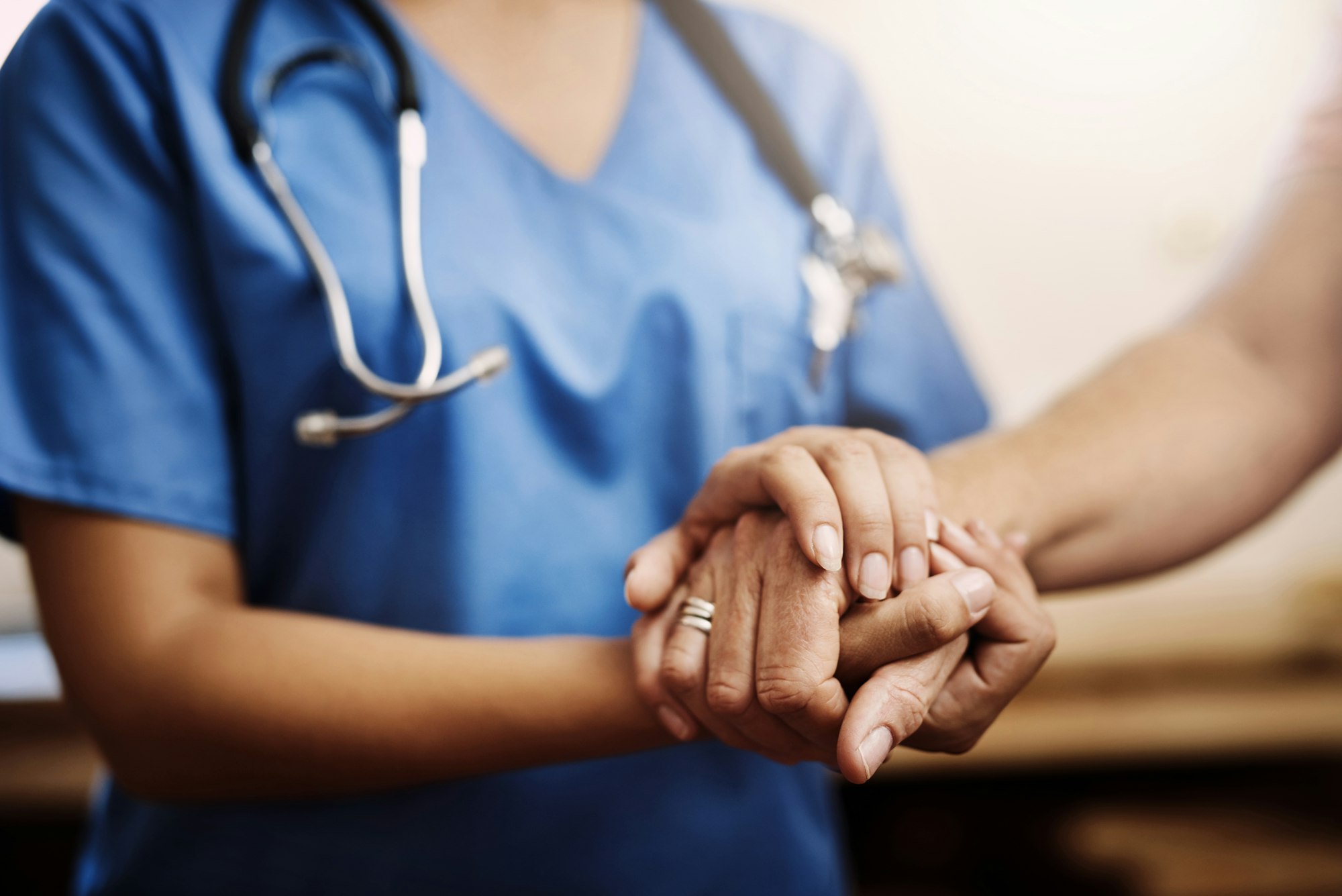 Cropped shot of an unrecognizable female nurse holding a senior womans hands in comfort